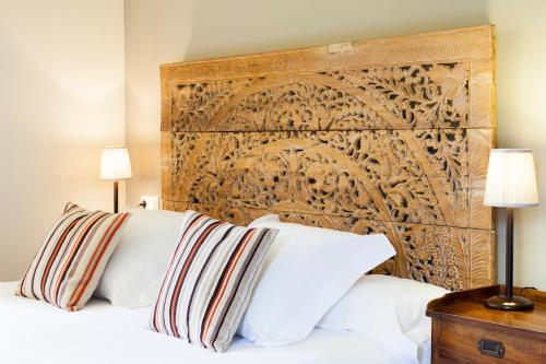尼格兰帕佐图查酒店的一张带白色枕头和木制床头板的床