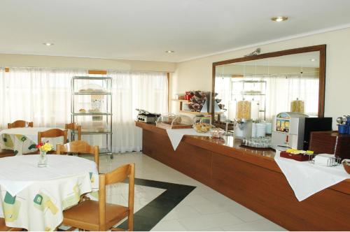 雅典奥米洛斯酒店的一间带桌子和镜子的柜台的餐厅