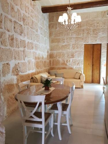 梅利哈Tal-Kampjin的一间设有桌椅和砖墙的用餐室