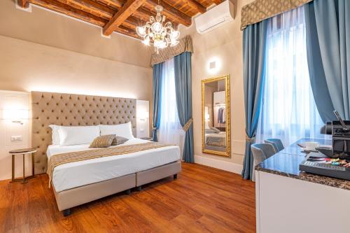 威尼斯Residenza La Duchessa Deluxe Rooms的配有一张床和一张书桌的酒店客房