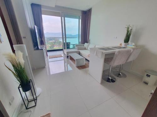 邦萨雷Delmare Beachfront Bangsaray Premium Condominium的白色的客厅配有桌子和沙发