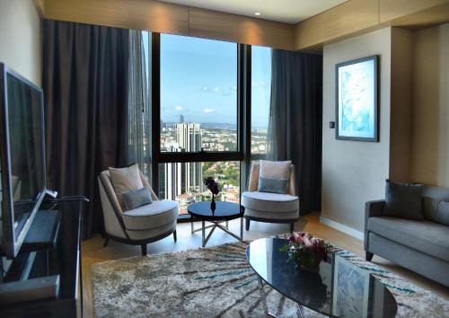 伊斯坦布尔伊斯坦布尔莱文特温德姆至尊酒店的带沙发和椅子的客厅以及大窗户。