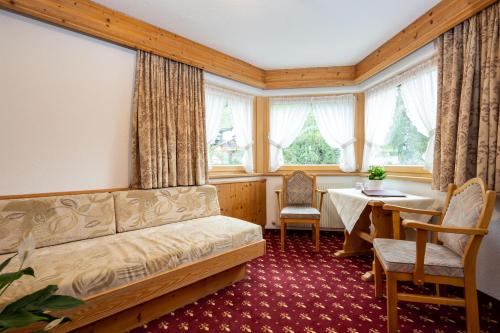 伊施格尔Hotel Garni Tyola的带沙发、桌子和窗户的客厅
