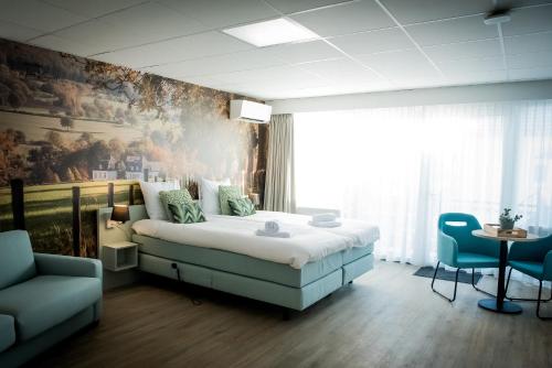 埃彭Hotel La Source Epen的卧室配有一张床,墙上挂有绘画作品