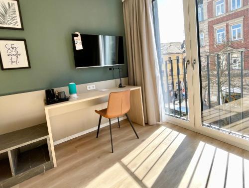 埃朗根兹沃赫豪斯u套房酒店&服务式公寓的客房设有一张桌子、一台电视和一把椅子