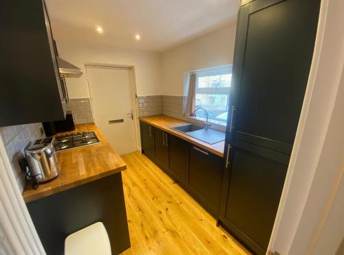 伊尔克利Spacious and bright 1 - bedroom rental unit的铺有木地板,设有带黑色冰箱的厨房