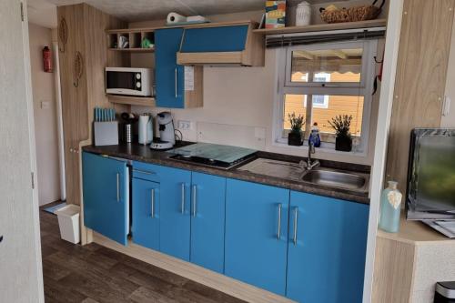 卡兰茨奥赫CS 9 - Vakantiepark Callassande的厨房配有蓝色橱柜和水槽