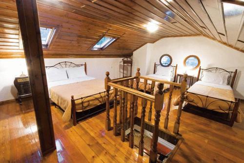 Emporio卡司达诺达索斯别墅的一间卧室设有两张床和木制天花板