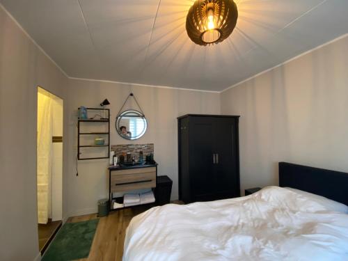 RijnsburgHoliday aan de Kust的卧室配有白色的床和灯