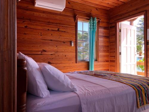 库尔克岛Blue Wave Guest House的一间卧室配有一张带木墙和窗户的床。