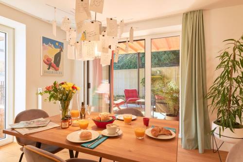 布雷根茨Rotes Haus Bregenz Pop-Up Wohnung的用餐室配有木桌和食物