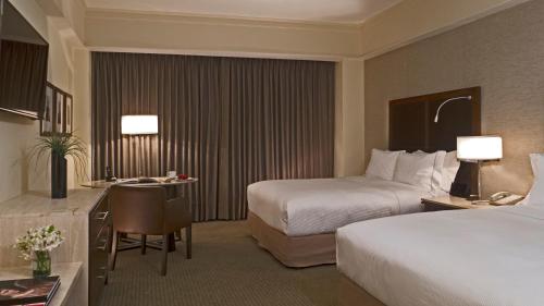 克雷塔罗盛大嘉年华美洲克雷塔罗酒店的酒店客房配有两张床和一张书桌