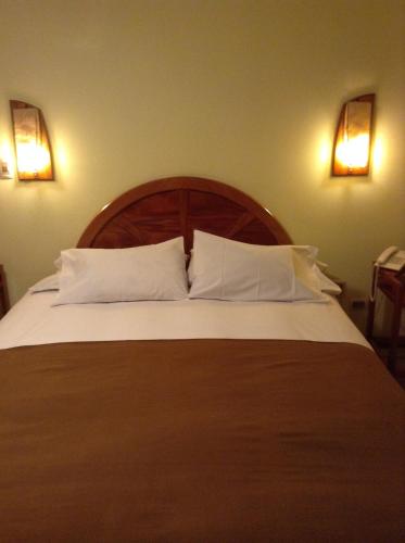 胡利亚卡Royal Inn Hotel Juliaca的卧室配有带白色枕头的大床