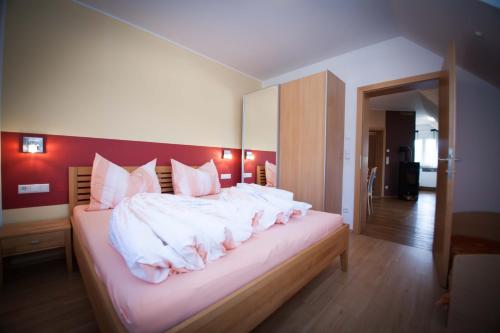 洛伊查赫Weinbau Pronegg vlg. Krainz的一间卧室配有带白色床单和粉红色枕头的床。