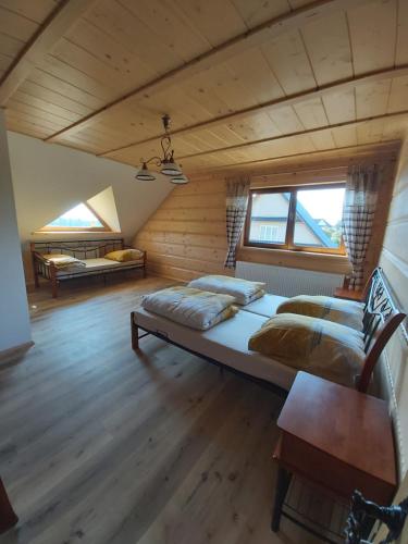 Podszkle-BukowinaAgroturystyka u Guta的一间铺有木地板的客房内配有两张床的卧室