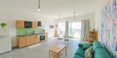 马尔扎梅米Fior di Sicilia Loft的一间带绿色沙发的客厅和一间厨房