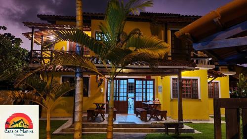 伊尔哈德博伊巴Pousada Casa da Marina的棕榈树前方的黄色房子