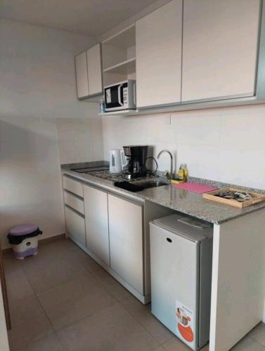 罗萨里奥Alquiler temporario Rosario的一间小厨房,配有白色的橱柜和台面