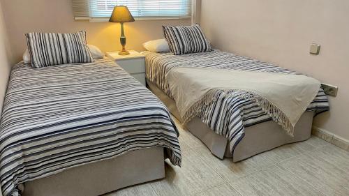 拉克鲁斯Elegante piso en Puerto de la Cruz的卧室内两张并排的床