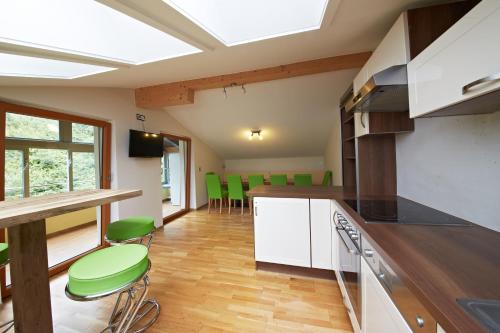萨尔巴赫Holiday Lodge Central的厨房配有绿色椅子和台面