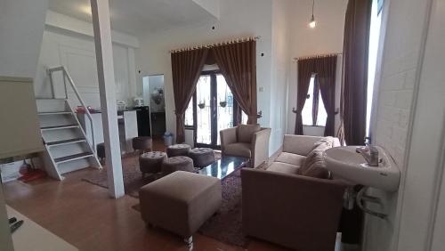 沃诺索博DIENG GHUZY HOUSE syariah family room的带沙发和水槽的客厅
