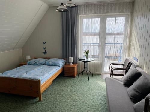 文戈热沃Niebieska Tawerna的一间卧室配有一张床、一张沙发和一个窗口