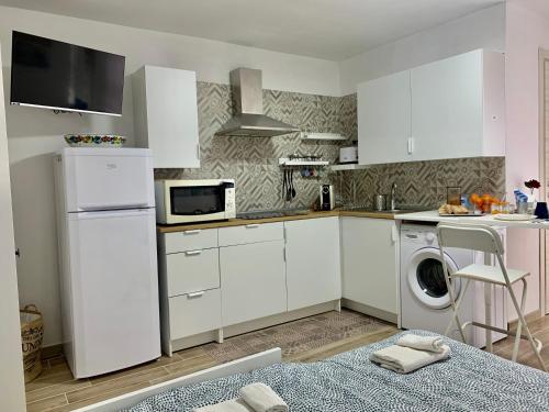 玛格丽塔萨沃亚Sunrise的厨房配有白色橱柜和洗衣机。
