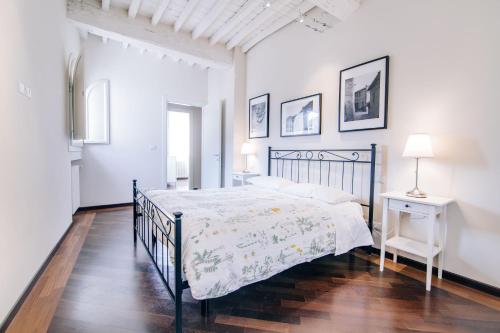 Uzzano伊尔博尔戈德利阿布鲁阿桂米度假屋的白色卧室配有黑色的床和一张桌子