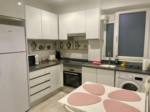 卡斯特利翁-德拉普拉纳Bianca Home的厨房配有白色橱柜和粉红色地毯。