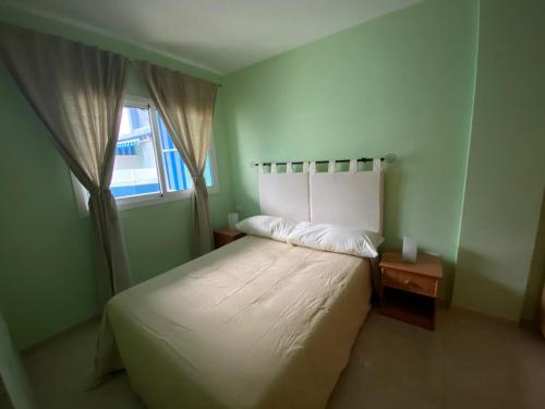 圭马尔港APARTAMENTO PUERTITO DE GUIMAR TEO的卧室配有白色的床和窗户。