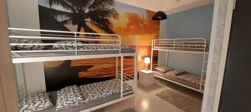 KontioniemiKontiolomat Oy的棕榈树壁画客房内的两张双层床