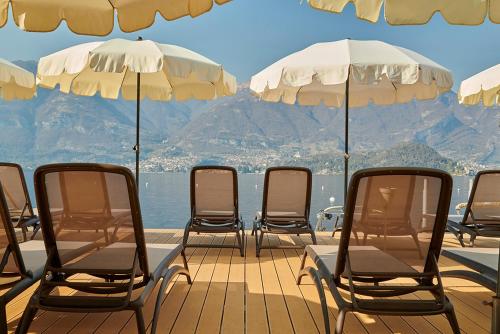 莱泽诺极光别墅酒店的甲板上的一组椅子和遮阳伞