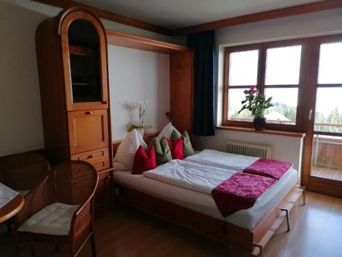 索内纳尔佩·纳斯费尔德Apartments Susanne und Jasmin - Haus Sonnleitn的一间卧室配有红色和绿色枕头的床