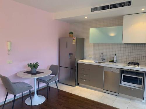 墨尔本Light-filled apartment in a dream location 150m away from University of Melbourne的厨房配有小桌子和冰箱。