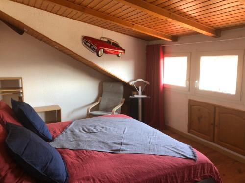 AltenbachLa maison bleue的卧室配有一张床铺,墙上挂着一辆红色汽车