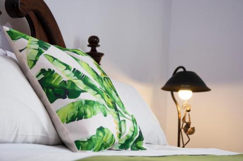 拉巴斯Inca's Room的一张带绿色和白色枕头的床和一盏灯