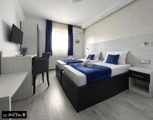 默主歌耶La Pietra Family Hotel的配有一张床和一张书桌的酒店客房