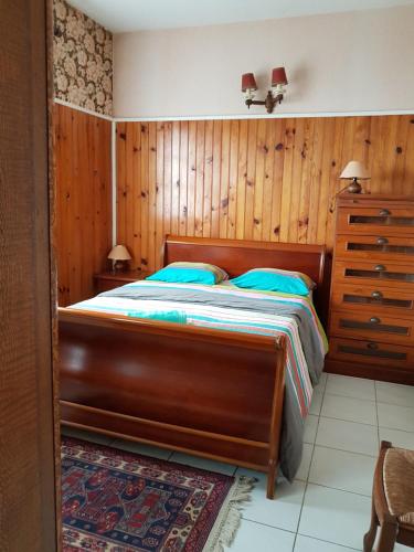 勒唐蓬La Villa du Volcan的一间卧室设有一张床和木墙