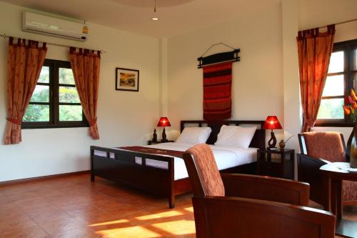 湄安迈仙民宿的一间卧室设有一张床和两个窗户。