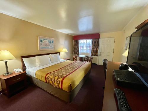 萨默斯波因特Passport Inn Somers Point - Somers Point的酒店客房设有一张大床和一张书桌。