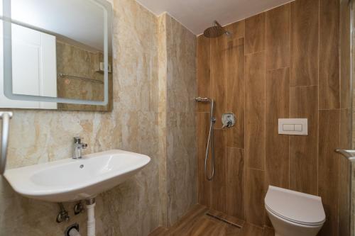 卡萨米尔Ventus Hotel的一间带水槽、卫生间和镜子的浴室
