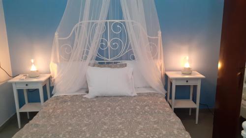 伊兹拉Diamond Suite的一间卧室配有一张带天蓬的床和两张桌子