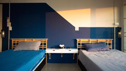 清莱Kaze House的蓝色墙壁客房的两张床