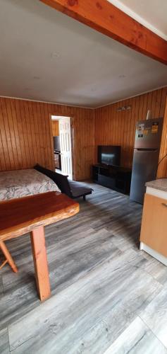 蒙特港El Capitán的客房设有一张床,铺有木地板。