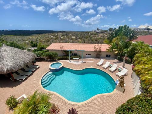 简蒂埃尔Home Sweet Home Jan Thiel Curacao best view的享有带椅子的游泳池和度假村的顶部景致