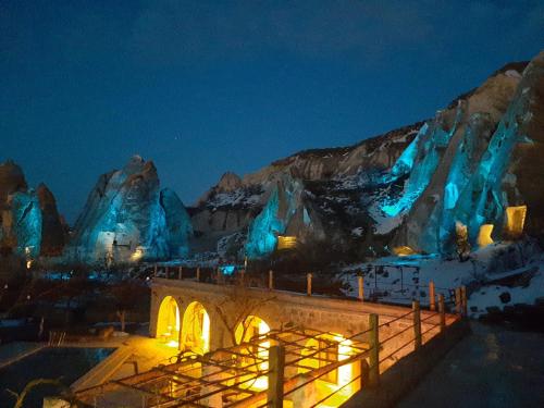 格雷梅Seven Rock Cave Hotel的享有冰镇的夜景,配有蓝色灯光