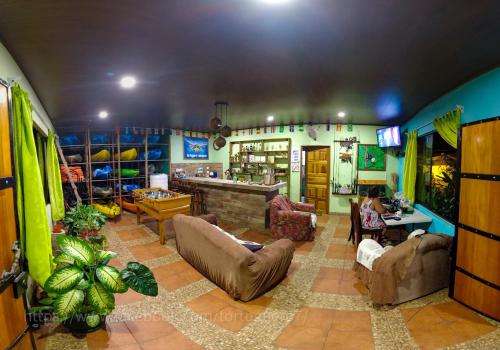 托尔图格罗Hostel Tortuguero 7BackPackers的带沙发的大型客厅和酒吧