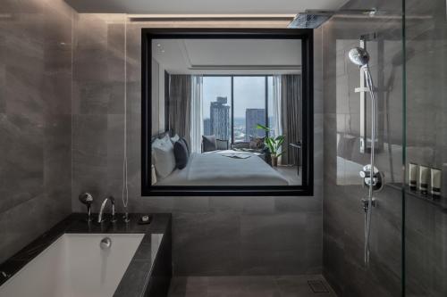 曼谷Ascott Thonglor Bangkok - SHA Plus Certified的一间带大镜子和浴缸的浴室
