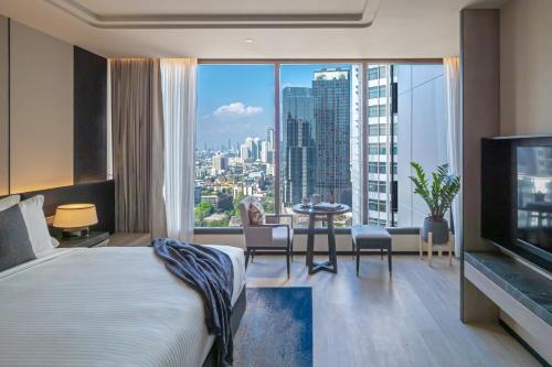 曼谷Ascott Thonglor Bangkok - SHA Plus Certified的酒店客房享有城市美景,配有一张床。