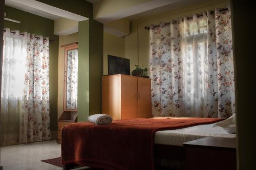 RongliAshraya Boutique Homestay的一间卧室配有床和两个带窗帘的窗户